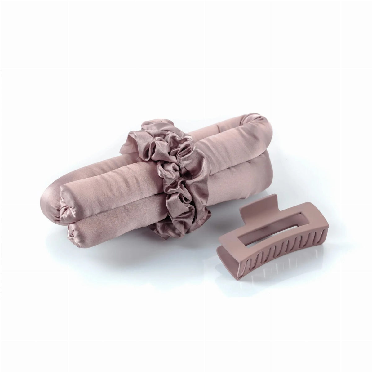 A mauve heatless curling rod set features a smooth satin curling ribbon secured with a matching scrunchie and accompanied by a sleek claw clip.