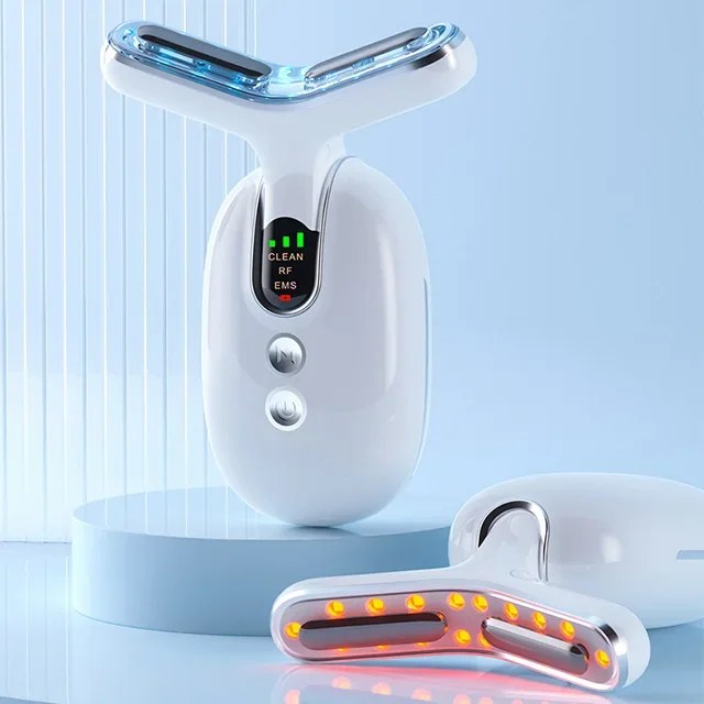 A white Y-shaped microcurrent skin tightening device and anti-aging face massager with a digital display rests on a blue pedestal.